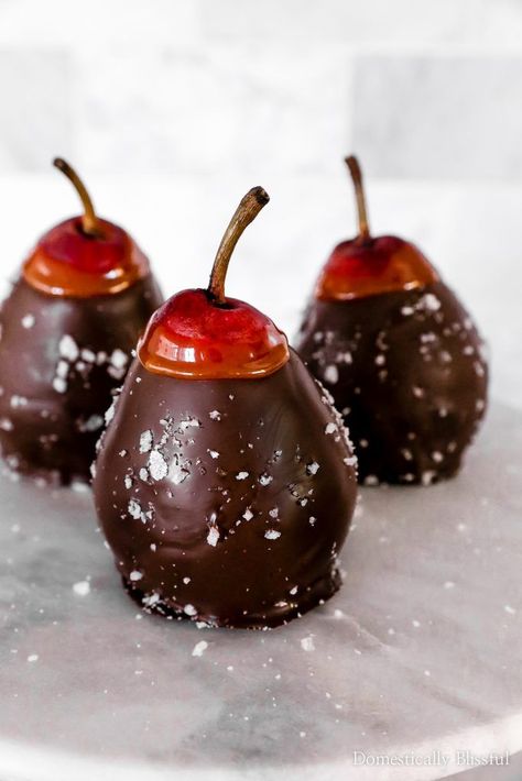 These Sea Salt Dark Chocolate Caramel Pears are a simple 4-ingredient recipe that is a perfect holiday party dessert. | 4 ingredient Christmas dessert that doubles as decor. | This dessert is perfect for a Thanksgiving dinner or Christmas dinner party. | These dark chocolate pears have a layer of caramel and dark chocolate, with a sprinkle of flaky sea salt. | This decadent winter dessert is sure to be a beautiful addition to your holiday party. Chocolate Covered Pears, Caramel Apple Slices, Domestically Blissful, Holiday Party Desserts, Apple Slice Recipe, Thanksgiving Chocolates, Fresh Fruit Desserts, Diy Cinnamon, Caramel Pears