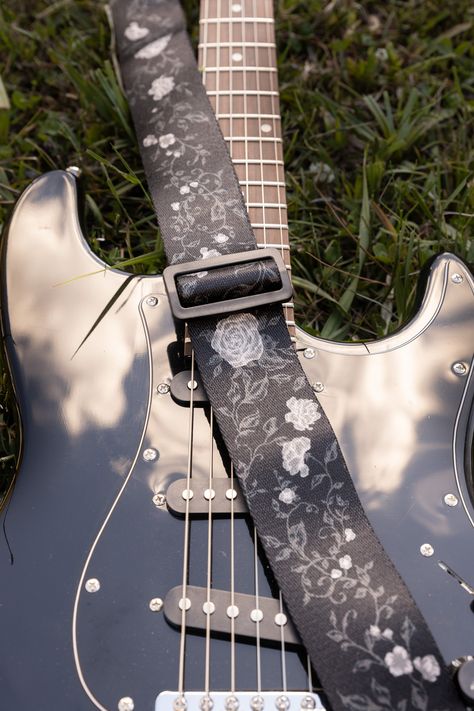 Black Vine Guitar Strap. This design features a black vine with white roses. The strap is made out of Polyester webbing and real black leather ends. Real leather provides the strength needed to ensure your instruments stay safe.  **PLEASE NOTE: Headstock adapter available as an add-on. My straps do not come standard with a headstock adapter. You may need this adapter depending on your guitar. Message me if you have any questions. MATERIAL * Polyester webbing  * Real leather WEIGHT & SIZE * 5 oz  * Adjustable From - 37" and 64" ( This is the total length of the strap at its minimum and maximum when attached to the instrument ) * Strap Width - 2" * Strap Leather end - 4" * Sizing may vary slightly Instagram: @megssdesign My Shop: megssdesign.com Under The Stars Aesthetic, The Stars Aesthetic, Custom Acoustic Guitars, Dream Guitar, National Park Patches, Mountain Tree, Guitar Obsession, Unique Guitars, Guitar Straps