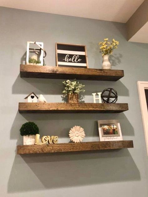 Our beautiful handmade floating shelves are great for storage in your living room, bathroom, bedroom, nursery, or laundry room. They add open shelving in your kitchen to make it look much bigger and more modern. Our floating shelves are perfect for pantry organization and will update any space. They can be made to look rustic or modern so they can fit any style! They are also gorgeous for adding a decorative look to any room and liven it up. These handmade custom floating shelves are sure to mak Floating Shelves Entryway Entrance, 20 Inch Shelves, Living Room Lighting Farmhouse, Floating Shelves Living Room Farmhouse, Home Office Wall Decor Floating Shelves, Living Room Wall With Floating Shelves, Styling Living Room Floating Shelves, Rustic Farmhouse Ideas Living Room, Shelving For Living Room Wall