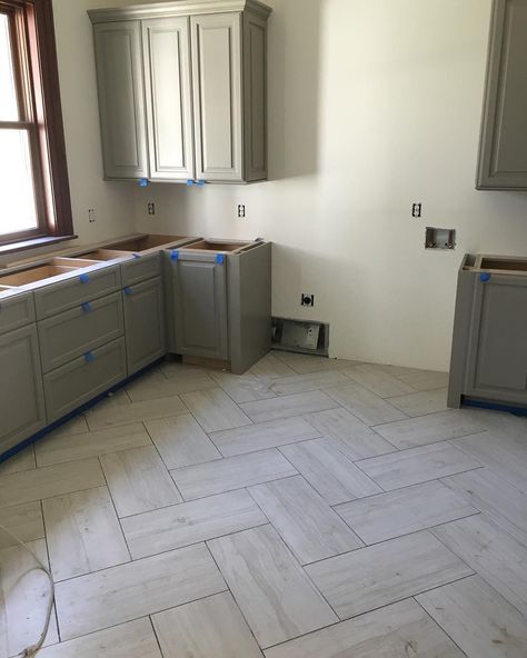 Love this herringbone tile pattern in this amazing laundry room that's in the works! Wood Floors With Tile Transition, Big Herringbone Tile Floor, 12x24 Tile Herringbone Pattern, Luxury Vinyl Tile Living Room, Large Tile Herringbone Floor, Engineered Tile Flooring, Large Herringbone Tile Floor Kitchen, Farmhouse Kitchen With Tile Floor, Laundry Room Herringbone Tile Floor