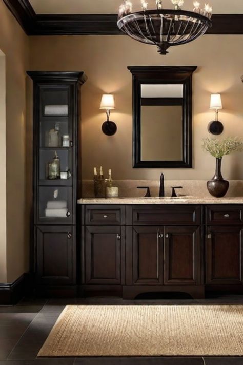 Modern bathroom with dark wood cabinets, a large mirror, and elegant lighting fixtures. Brown Bathroom Cabinets Decor, Bathroom With Dark Walls, Black And Brown Bathroom, Bathroom Color Schemes Brown, Grey And Beige Bathroom, Mahogany Bathroom, Earth Tone Bathroom, Small Dark Bathroom, Dark Brown Bathroom