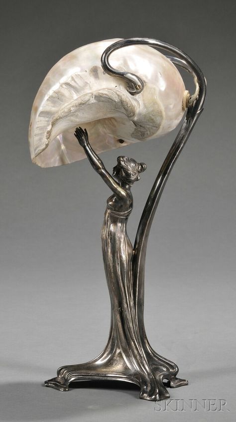 Art Nouveau Silver-plate and Mother-of-pearl Figural Lamp, Germany, late 19th/early 20th century, mark of Wurttembergische Metallwarenfabrik (WMF), the base formed as a scantily clad nymph reaching upward towards the shade formed by a large nautilus shell, bottom stamped "as WMFB I/0," ht. 13 3/4 in. Chocolate History, Art Nouveau Lighting, Art Nouveau Lamps, Lampe Art Deco, History Essay, Style Writing, Gold Chocolate, Art Nouveau Furniture, Apa Style