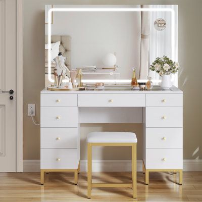 Get the ideal lighting for your morning routine with this modern makeup vanity. The wide mirror allows you to see every angle, and it features a touch switch that lets you customize your lighting scheme with the LED bulbs' 3 colour modes. This vanity has 9 drawers, offering you ample space to tuck away cosmetics, perfumes, and jewellery. The soft seat is set at the right height. The dresser comes with detailed instructions and accessories and can be installed by 2 people in about 40 minutes. | L Bedroom Gold And White, Preppy Vanity, Vanity Set Up, White Vanity Desk, Beige Bedroom Decor, Wide Mirror, White Makeup Vanity, Lighting Scheme, Modern Makeup Vanity