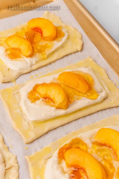 Peach Cream Cheese Danish is a delicious sweet treat for breakfast or brunch, with an irresistible filling and a flakey puff pastry crust! #RealHousemoms #peach #creamcheese #danish #cheesedanish #peachdanish #breakfast #brunch #creamcheese #jelly Fruit And Cream Cheese Breakfast Pastry, Cheese Danish With Pie Crust, Phyllo Dough Recipes Dessert Peach, Puff Pastry Recipes With Peaches, Peach Strudel Puff Pastries, Puff Pastry Dessert Peach, Peach And Cream Cheese Puff Pastry, Peach Cream Cheese Danish, Peach Phyllo Recipes