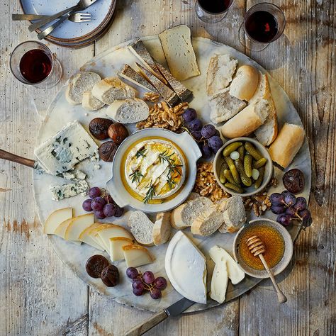 A wooden grazing board with various cheeses and ramekins English Cheese Board, British Cheese Board, Manchego Cheese Board, Rustic Cheese Board, Italian Cheese Board, Cheese Board Aesthetic, Brie Cheese Board, French Charcuterie Board, Summer Cheese Board