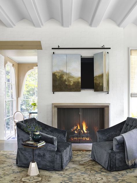 Hide TV behind a custom bifold painting and adorn with a long picture light. Tv Over Fireplace, Furnitur Ruang Keluarga, Hidden Tv, Hemma Diy, Indoor Fireplace, Decoration Room, Modern Fireplace, Cozy Fireplace, Winter Home Decor