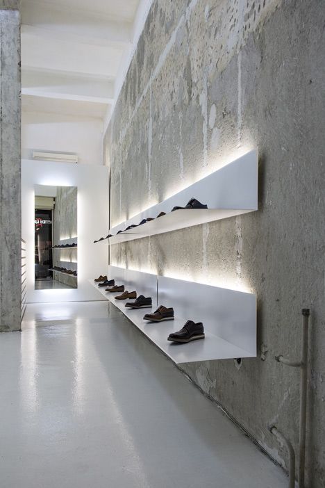 White shelves hang from concrete walls at shoe shop by Elia Nedkov Showroom Ideas, Shoe Store Design, Retail Lighting, Retail Interior Design, Retail Inspiration, Store Interiors, White Shelves, Retail Store Design, Retail Interior