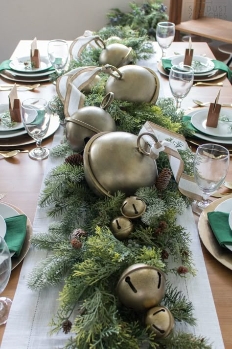 Oversized brass jingle bells atop greenery for simple table centerpiece #tablescape #vintage #christmascenterpiece #gold #greenery Jingle Bell Tablescape, Vintage Jingle Bells, Oversized Jingle Bells, Christmas Bells Centerpiece, Formal Christmas Party Table Centerpieces, Christmas Jingle Bell Centerpiece, Oversized Christmas Bells, Christmas Tree Farm Theme Decor, Jingle Bell Centerpiece