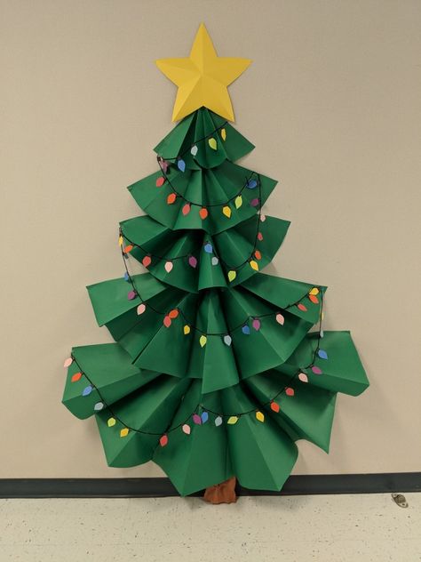 3-D Christmas tree bulletin board. Christmas Decoration Bulletin Board, Diy Christmas Tree Classroom, Classroom Paper Christmas Tree, Christmas Tree Classroom Decoration, Christmas Tree For Classroom Door, Christmas Decorations Bulletin Boards, Christmas Tree Out Of Construction Paper, 3d Paper Christmas Tree On Wall, Classroom Christmas Tree Theme