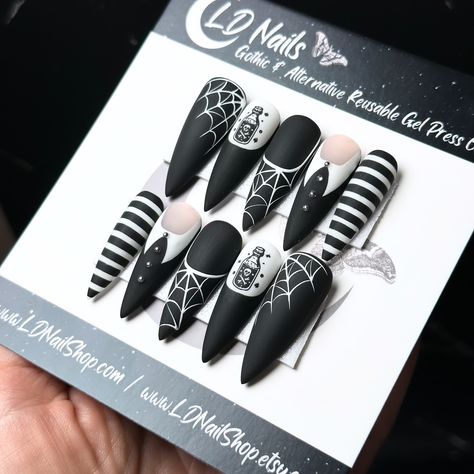 Want nails as sharp as Wednesday’s wit? Look no further; these press ons got your goth covered! 🖤 ☠️ 🕸️ Little Storm Cloud on Après Long Stiletto 💅🏻 ⁣ .⁣ .⁣ .⁣ .⁣ .⁣ #wednesdaymood #halloweencostume #halloweencountdown #spookynails #wednesdayaddamsnails #gothicnails #halloweennails2023 #spookynailart #spooky #gothnails #gothnailsofinstagram #pressonnailset #longnails #wednesdayedit #wednesdayaddams #wednesdaycosplay #wednesdayvibes #nailartist #alternativenails #addamsfamily #halloweennails... Halloween Nails Adams Family, Spooky Press On Nails, Adams Family Nail Designs, Wednesday Themed Nails, Wednesday Nail Designs, Adam’s Family Nails, Goth Press On Nails, Wednesday Addams Nails Ideas, Wednesday Nails Ideas