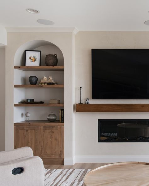 The perfect spot to display all your favorite things! 🤍 We’re obsessed with the charm these knotty alder arched built-ins bring to this basement living space. . . . Dealer: @two30nine Designer: @juliatwo30nine Arched Cabinets By Fireplace, Chimney Built Ins, Bookcase Next To Fireplace Freestanding, Arched Shelving Fireplace, Arched Tv Built In, Arched Entertainment Center, Arch Built In Shelves Fireplace, Chimney Renovation, Fireplace With Arched Built Ins