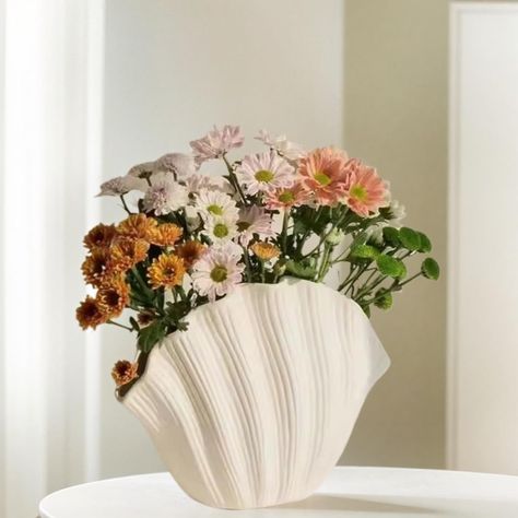 PRICES MAY VARY. Unique and Aesthetic Design: Immerse your home in an oceanic theme with our unique shell-shaped vase. Flaunting a classic ceramic finish and an aesthetically appealing Nordic , this vase is a addition to all décor including modern, farmhouse, offices, shops, restaurants, and cafes High Quality Craftsmanship: Our shell-shaped vase is a fine example of superior craftsmanship. Masterfully crafted from top-notch ceramic materials, this piece resonates with the exceptional skills and Centerpiece Table, Nordic Decor, Keramik Vase, Home Decor Vases, Dried Floral, Flower Accessories, Ceramic Flowers, Ceramic Decor, Aesthetic Room Decor