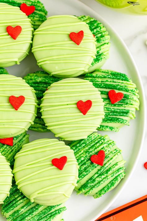 These Grinch chocolate covered Oreos put a fun Christmas twist on a classic treat. These cute and colorful Christmas cookies are an adorable and delicious addition to your holiday celebrations. Green Christmas Treats, Christmas Dessert Goodie Bags, Dessert Christmas Gifts, Grinch Oreo Cookies, Cute Christmas Desserts Grinch, White Chocolate Covered Oreos Christmas, Chocolate Covered Oreo Christmas, Grinch Chocolate Covered Oreos, Christmas Nutter Butter Cookies