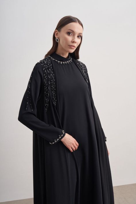 Elevate your modest fashion with The Abaya of all the Abaya's - Black Abaya with Design Sleeve. This sophisticated piece is not just another black abaya; it's a statement of elegance and grace. Features: Classic Black Fabric: A timeless color that exudes elegance and versatility. Embellished Rhinestone Design: Adds a touch of sparkle, transforming the simple into the spectacular. Shoulder Over Layer: Offers an extra layer of sophistication with its unique drape. Perfect for any occasion, whether it's a formal gathering or a special celebration, this abaya ensures you stand out while embracing modesty. Why You'll Love It: Chic Detailing: The rhinestone design adds just the right amount of glamour. Comfort & Fit: Designed for a flattering fit without compromising on comfort. Versatile Style: Unique Abaya Designs, Abaya Dress Design, Essential Fashion Pieces, Abaya Black, Chic Belt, Essential Fashion, Modern Kimono, Dress Stands, Black Abaya