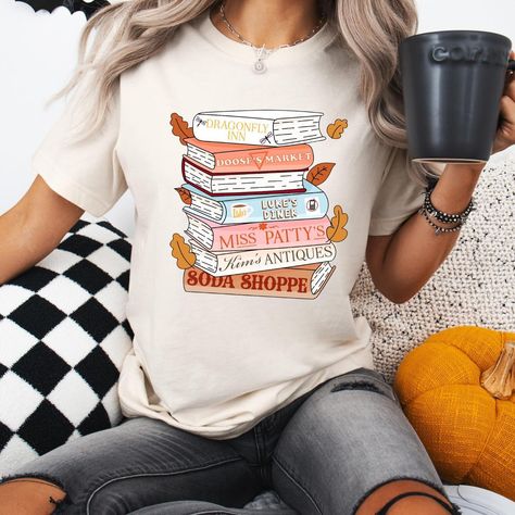 For all my Gilmore Girls ☕️🌼📚🎃 All items available to order now on our Etsy! 🤍 Don’t forget 15% off ALL new UVDTF/DTF printed shirts & cups!! 🤩🤩 Do you like Gilmore Girls!? What’s your favorite fall comfort show!? 🍂 Gilmore Girls Tshirt, Dragonfly Inn, Boutique Tees, Lukes Diner, Comfort Show, Girls Tshirt, Tshirt Ideas, Girls T Shirt, Gilmore Girls