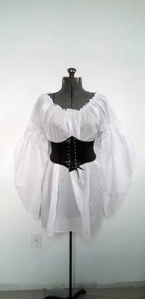 "UNIQUE CUSTOM STYLE, STAND OUT FROM THE CROWD! Versatile Chemise for all Your Costume Needs On or Off shoulders 100% Cotton 32\" Long Chemise Elastic neckline, On or Off Shoulder Long Flowing Sleeves with 2 Elastic Puffs, On Or Off Shoulder *SUPER VERSATILE* YOU'LL LOVE THIS CHEMISE FOR ALL YOUR RENAISSANCE, PIRATE, STEAMPUNK, WENCH, PEASANT OR MERCHANT COSTUMES. PERFECT FOR FAIRES, PLAYS, CIVIL WAR REENACTMENTS, EDWARDIAN, VICTORIAN & BOHO FESTIVALS AND MUCH MORE! SIZES Regular US Women's White Chemise, Victorian Boho, Pirate Dress, Female Pirate Costume, Brown Corset, Flowing Sleeves, Pirate Outfit, Fair Outfits, Pirate Fashion