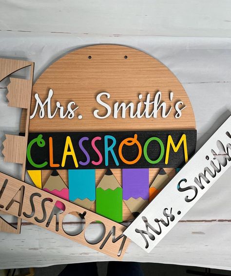 Create your own door sign with this DIY door sign kit, or host a DIY painting party. This unfinished custom classroom door hanger kit is the final touch to getting your classroom ready for the new school year. It is customizable with the teacher’s name, door round color or stain, and pencil colors. The unfinished door round and design elements are laser-cut from birch plywood. The sign is available in 16", 18", or 20" size. The door sign is available with or without holes for hanging. Twine Teacher Door Hanger Classroom Signs, Diy Painting Party, Classroom Door Sign, Teacher Door Sign, Classroom Door Signs, Teacher Door Signs, Teacher Door, Diy School, Teacher Doors