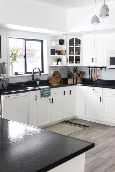 Wow! This stunning modern kitchen was transformed in just one weekend! Love the design ideas in this stunning black and white kitchen! The kitchen features white cabinets, black countertops, black hardware, matte black faucet, black sink, and wood accents White Kitchen Cabinets Black Countertops Grey Walls, Dark Countertops Kitchen Color Schemes, Luxury White Kitchen Design, White Cabinets Black Countertops, Luxury White Kitchen, Countertops Black, Matte Black Faucet, Interior Dapur, Black And White Kitchen