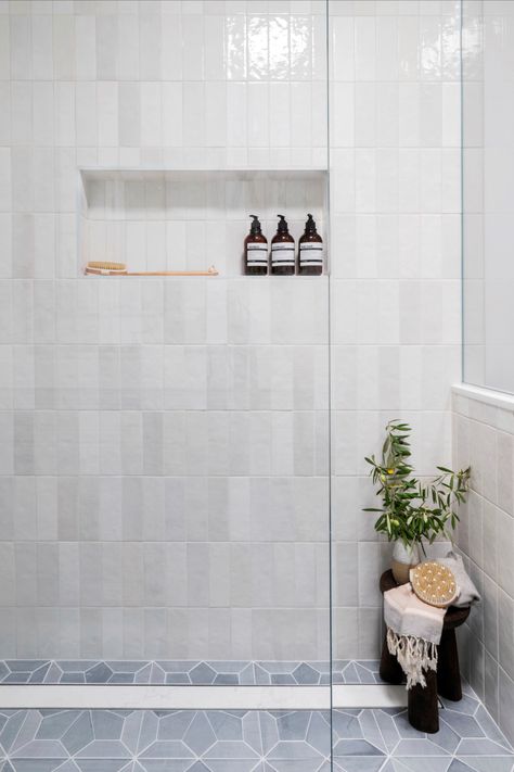 We love walk-in showers for their practical use. When space is limited, not having a door makes a huge difference in a small space. We ran the marble tiles all throughout the bathroom and shower to make the space look and feel larger. We paired the marble floors with white vertical stacked tiles in a white subway tile with a lot of tone variation. Stacked Subway Tile Bathroom, Shower With Linear Drain, Vertical Subway Tile Bathroom, Vertical Shower Tile, Timeless Bathroom Design, Walk In Shower Ideas, Subway Tile Showers, Walk In Shower Enclosures, Wet Room Shower