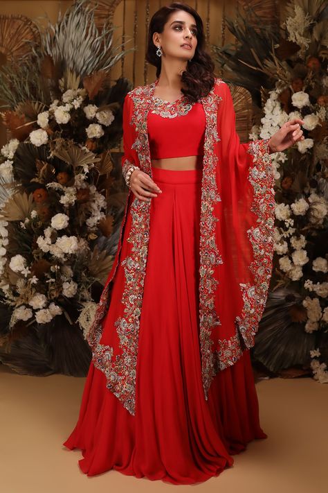 Featuring a red lehenga in georgette base. It is paired with a matching blouse and a high-low cape.  FIT: Fitted at bust and waist. COMPOSITION: Georgette. CARE: Dry clean only. Dress For Sangeet, Red Georgette Lehenga, Red Sharara, Cape Lehenga, Georgette Lehenga, Saree Gown, Red Lehenga, Brunch Wedding, Embroidery Designs Fashion