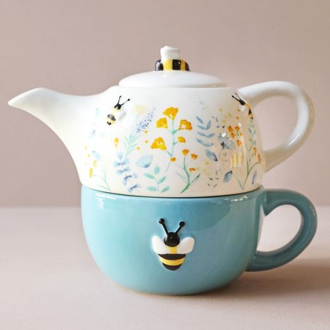 Key Features Floral bee design Teapot & cup set Colour - cream & blue Material - Ceramic Dimension - teapot: 19 cm x 8.5 cm, cup: 19 cm x 6 cm Presented in a pretty gift box Add some floral beauty to your tea time with this lovely teapot & cup set with a delicate wildflower & bumblebee design. The large blue mug features an embossed bee on the side. The cream coloured ceramic teapot sits above the cup and is adorned with floral details in blue and yellow tones. Bumblebees are dotted around the sides of the teapot whilst a larger one is placed on top of the lid. The sweetest gift for a friend or family member that loves to sit in their garden and enjoy the beauty of the flowers an the buzz of the bees. With this set they can enjoy that feeling even of the rainiest of days! So pretty! Kitchenware Products, Painted Teapot, Blue Tea Cup, Teapot Design, Teapot Set, Blue Mug, Clay Teapots, Ceramic Teapot, Teapots And Cups