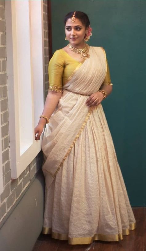 Anu Sithara in a kasavu lehenga by Mirach for onam Kerala Onam Dress For Women, Dawani Designs Kerala Style, Onam Special Dress For Women, Kasavu Lehenga, Kasavu Saree Blouse Designs, Kasavu Skirt And Top, Kasavu Half Saree, Onam Dress Ideas, Onam Shoot