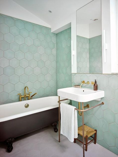 Contemporary bathroom boasting green hexagon wall tiles encompasses a black clawfoot bathtub paired with an antique brass floor mount tub filler. Blue Hexagon Tile Bathroom, Green Hexagon Tile, Hexagon Bathroom, Hexagon Tile Bathroom, Hexagonal Tiles, Green Tile Bathroom, Hexagon Tile, Inspiration Bathroom, Bad Inspiration