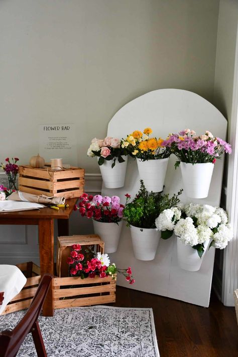 Make a gorgeous flower bar with a foam board backdrop! This DIY was under $50 and a great way to create an activity and favors at a shower. Wooden Flower Holder, Flower Bar Chalkboard Sign, Bloom Bar Baby Shower Ideas, Diy Flower Bucket Stand, Succulent Bar Diy, Flower Bar Birthday Party, Diy Bloom Bar, Bouquet Making Station, Flower Bouquet Display