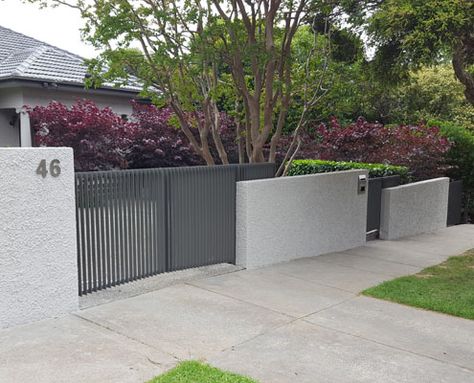 A unique front fence built by Black Barrow in Melbourne. Australia. The fence was constructed using reinforced concrete blocks, rough-cast render and powder-coated metalwork. The fence was designed to take advantage of the sloping site and to minimise damage to the established garden and paving during construction. Brick Fence Ideas, Yard Fence Ideas, Hydrangea Plant, House Fence, Fence Plants, Sloped Yard, Yard Fence, House Fence Design, Rustic Fence