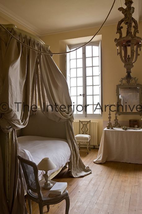 Another bedroom is furnished with a lit a la Polonaise, the bed and dressing table draped in a natural linen Bed Drapes, Cane Back Chairs, White Units, Classical House, French Interiors, Bedroom Bedside Lamp, Old Beds, Blue White Decor, Linen Lights