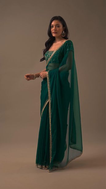 "Introducing our enchanting teal green plain organza saree, a celebration of simplicity and opulent detailing. This saree showcases a cutdana border that adds a touch of elegance. The unstitched blouse fabric features heavy cutdana work all over. EVENT - Perfect for evening parties. The saree comes with a matching unstitched blouse." Floral Blouse Designs, Optical Illusion Dress, Cutdana Work, Simple Saree Designs, Saree Wearing Styles, Latest Model Blouse Designs, Green Plain, Lehenga Designs Simple, New Saree Blouse Designs