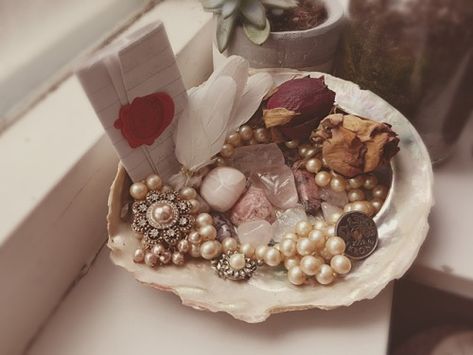 Aphrodite offering dish: It contains fake pink pearls, a broche, crystals for attracting love, a letter I wrote to her, white dove feathers, dried roses, and a Norse krone with a dove on it (not mine, simply inspiration) Aphrodite Altar, Attracting Love, Aphrodite Aesthetic, Aphrodite Goddess, Dried Roses, Witches Altar, Wiccan Altar, Pagan Altar, Pink Pearls