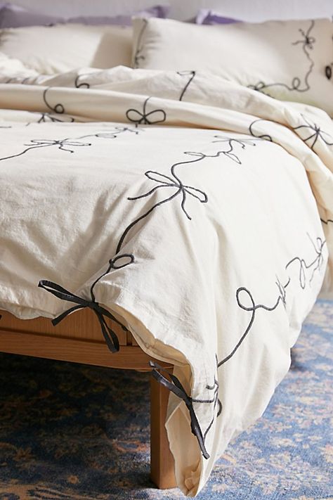 Our fave femme icon gets a chic refresh with this lightweight cotton embroidered duvet cover. Its crisp construction features textural bows stitched allover the top panel with a solid cotton panel at the reverse for a silky-soft finish. Pair it with our Lacey Bows Sham Set for a coordinated bedding set. Available exclusively at Urban Outfitters. Features Chic bow duvet cover from UO Home in crisp cotton Finished with textural bows allover the top panel Backed with a solid cotton panel Hidden but Bow Bedding Urban Outfitters, Trending Comforter Sets, Gray Bedroom White Furniture, Black And Pastel Bedroom, Plush White Bedding, Winter Duvet Cover, Bedding Aesthetic Cozy, Matching Curtains And Bedding, White Bed With Colorful Accents