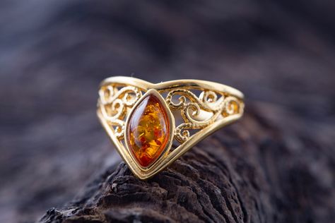 Art Gemelli present's lovely ring made of natural Baltic amber. It has been lovely set in sterling silver and covered by 14 CT gold layer. Cognac type of amber. Celtic heritage inspired design. Perfect for everyday use. Ideal gift.    Perfectly polished cognac Baltic amber set in 925 sterling silver setting and covered by 14 CT gold layer.    This ring comes with LIFETIME CRAFTWORK WARRANTY for your peace of mind. Gift wrap is also provided.    We source our amber from Baltic coast often looking Gold Amber Ring, Amber And Gold Jewelry, Amber Diamond Ring, Amber Ring Engagement, Amber Engagement Ring, Elegant Gold Jewelry, Amber Rings, Fashion Jewelry Rings, Family Ring