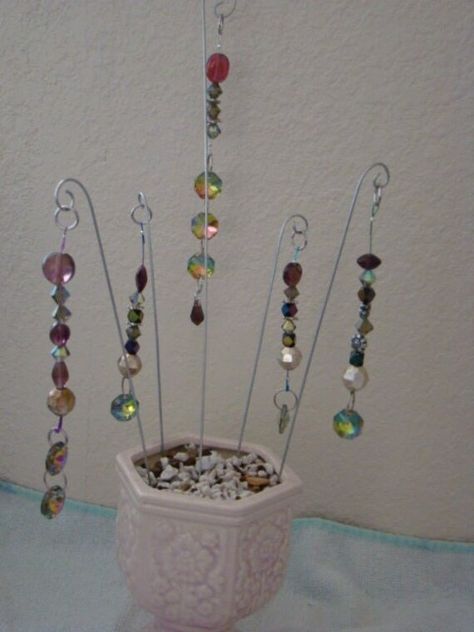 "Four different fairy garden stakes with beaded dangles and a large aurora borealis crystal at the bottom - your choice. Style A - has 4 beads, 2 spacers, and three AB crystals at bottom for that extra bling. 6\" long on 11 1/2\" stake. Style B - has 7 beads and two AB crystals at bottom. 5\" long on 8\" stake. Style C - has 8 beads and one AB crystal at bottom. About 5\" long on 8\" stake. Style D - has 6 beads, 2 spacers, and one AB crystal at bottom. 4\" long on a 7\" stake. Style E - has 6 b Beaded Garden Stakes Diy, Beaded Plant Stakes, Beaded Garden Stakes, Plants Jewelry, Fairy Garden Stakes, Garden Sticks, Plant Pokes, Plant Stick, Plant Sticks