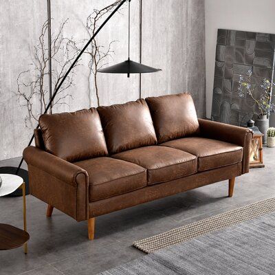 Form meets function with this vintage-inspired sofa. It features a solid oak frame with four dowel legs to give your space a modern vibe. This couch is also wrapped in faux leather(Suede fabric) upholstery for a lived-in look, and it comes in a rich brown hue that blends in with a variety of color schemes. Foam filling gives you extra support whenever you need some time to relax. Round arms and a cushion back round out this classically industrial design. Partial assembly is required: Just attach Couch Sets, Mid Century Modern Couch, Faux Leather Couch, Brown Leather Couch, Small Sectional, Small Sectional Sofa, Lodge Homes, Futon Couch, Faux Leather Sofa