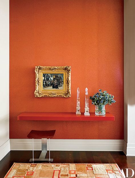 A gilt-framed Teodor Axentowicz genre scene contrasts with a high-gloss shelf in the entrance hall | archdigest.com Rich Apartment, Orange Room, Orange Rooms, Manhattan Apartment, Orange Interior, Apartment Renovation, Orange Walls, Athletic Club, Entrance Hall