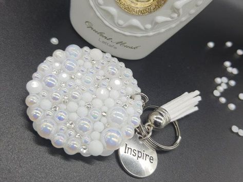 Our beautiful handmade keychains are adorned on both sides with a selection of sparkling flat backed pearl, crystal, jelly, glass and transparent resin rhinestones. Each keychain is attractively finished with a coordinating tassel and a pendant of your choosing. These will make a perfect gift or Christmas stocking filler.  Once you have chosen your colour and pendant, your keychain will be made to order. Each keychain is bespoke with uniquely placed rhinestones so no two keychains will be identical. If you have a preference between a circle or heart shape, please let me know in the "message to seller" box when checking out. You will receive your keychain shape at random if no preference is indicated. Please allow a turnaround time of up to 7-10 days after your order for production and deli Resin Circle Keychain, Circle Keychain, Crystal Jelly, Sparkle Flats, Handmade Keychains, Transparent Resin, Christmas Stocking Fillers, Pearl Crystal, Stocking Filler