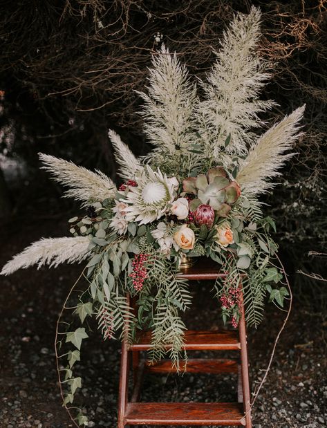 It’s taken over the pages of Green Wedding Shoes and our boho-wedding-lovin’ hearts: pampas grass! The greatest floral trend that’s already happening in weddings from California to Australia, this ornamental grass is native to South America and grows 10 to 13 feet high with a six-foot wing span. We’re spotting it in every aspect of... Bohemian Centerpieces, Rustic Bohemian Wedding, Blue Wedding Centerpieces, Bohemian Table, Grass Wedding, Rustic Bouquet, Wedding Table Flowers, Pampas Gras, Wedding Flower Decorations