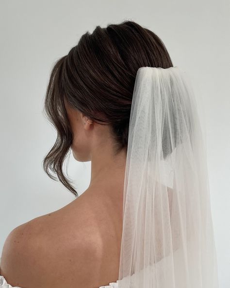 You already know how I feel about the knotted bun, but let’s also see it with a veil🤭 ⁣ SWIPE ⁣ When it comes to veil placement there are 3 different options for a low bun.⁣ ⁣ -Higher on the crown, which gives it more visibility from the front.⁣ -Above the bun, like this photo.⁣ -Underneath the bun, to really showcase the knot.⁣ ⁣ Above the bun is the most popular pick, but all are equally beautiful and I have bride’s that choose each option. It all comes down to your personal preference!⁣ ⁣ ... Bridal Ponytail Veil, Classic Bridal Updo With Veil, Wedding Day Low Bun, Bride Hairstyles For Low Back Dress, Low French Twist Wedding Hair, Low Bun Wedding Hair Veil, Wedding Hairstyles Bun With Veil, Bridal Hair French Twist With Veil, Wedding Hair Brunette With Veil