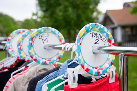 A Rack of Clothes is Separated By Size With Paper Plates Yard Sale Clothing Display Ideas, Prop Organization, Yard Sale Clothes, Yard Sale Clothes Rack, Cleaning Garage, Yard Sale Display, Yard Sale Hacks, Yard Sale Organization, Garage Sale Organization