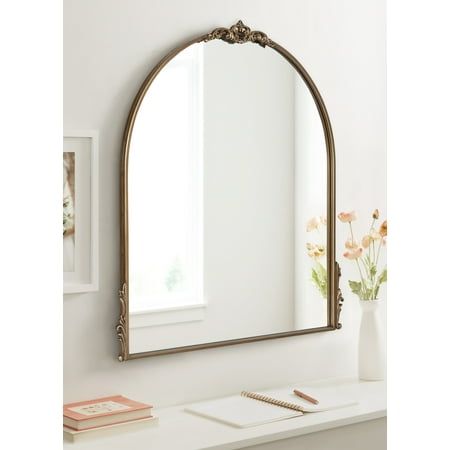 Bring the timeless beauty of French provincial design into your home with the vintage Myrcelle wall mirror. This beautiful accent piece features a sophisticated arched shape with ornate garland details along the edges and crown of the frame. Its antique gold finish captures the vintage look it strives for, providing a warm and storied visual that draws the eye and captures the imagination. The Myrcelle mirror is a striking statement with its large size, measuring 30 inches wide by 1.5 inches dee Mirror Above Fireplace Mantle, Mirror Above Fireplace, Nursery Mirror, French Provincial Design, French Vanity, Big Mirror, Arched Mirror, Arch Mirror, Entryway Console