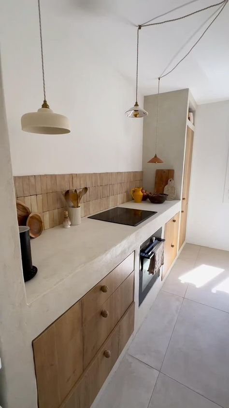 This Mediterranean-inspired kitchen blends rustic and contemporary elements with stucco countertops, wood cabinetry, and rattan pendant lights. An integrated bench with plush cushions adds comfort. Earthy tones and minimalist decor enhance the coastal vibe. SHOP similar products tagged. #MediterraneanKitchen #RusticCharm #StuccoCountertops #WoodCabinetry #RattanPendants #BenchSeating #MinimalistDecor #EarthyTones #CoastalVibe #HomeDecor #KitchenDesign #Benchseatingc#rattan #rattandecor Modern Mediterranean Kitchen, Mediterranean Style Kitchen, Cement Kitchen, Resin Kitchen, Mediterranean Kitchen Design, Contemporary Mediterranean, Inspiration Deco, Mediterranean Interior, Mediterranean Kitchen