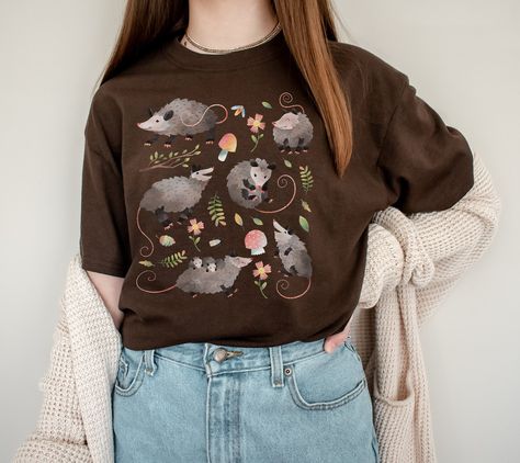 Cute Cottagecore Possum Gift for people that are opossum fans or opossum lovers and for cottage core aesthetic lovers. Add this super soft Cottagecore Clothing to your Aesthetic clothing collection. Available on tshirt, sweatshirt and hoodies: https://www.etsy.com/shop/TheNims?search_query=possum For other Christmas items, click here: https://www.etsy.com/shop/TheNims?r&section_id=30682947 Browse through my other awesome items here: http://thenims.etsy.com/ UNISEX TEES Gildan 5000™ (CUSTOMER FAV Earthy Tone Outfits, Possum Shirt, Soft Cottagecore, Aesthetic Lovers, Cottage Core Shirt, Christmas Kawaii, Cute Cottagecore, Cottage Core Aesthetic, Aesthetic Clothing