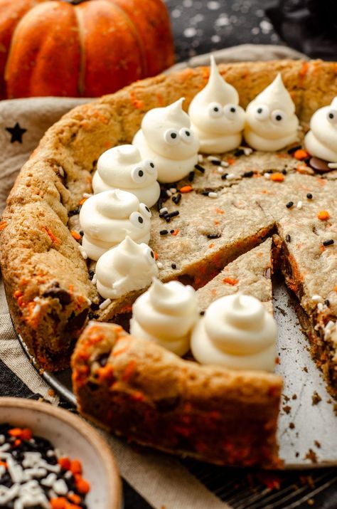 Turn any cookie cake into a Halloween spectacle with simple frosting ghosts. This easy Halloween cake recipe features chocolate chips and festive sprinkles for a fun Halloween cookie cake for kids and adults alike. This is a great option for Halloween potluck ideas for work or a Halloween party dessert recipe. Everyone will want more of this Halloween chocolate chip cookie cake. | halloween cookie cake designs easy | halloween cookie cake recipe | how to make frosting ghosts Halloween Party Food Cute, Halloween Desserts For Contest, Gluten Dairy Free Halloween Treats, Monster Mash Cake, Halloween Slice And Bake Cookies, Ghost Cookie Cake, Halloween Food Adults, Fun Kid Desserts, Halloween Cookie Cake Ideas