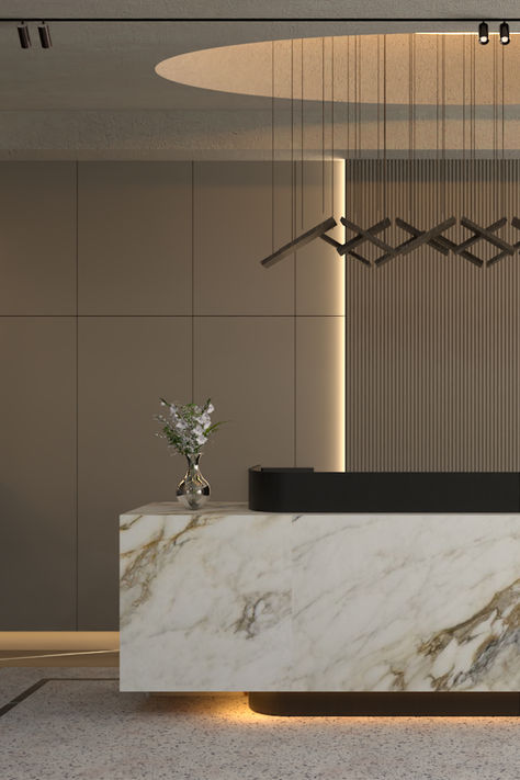 A modern reception area featuring a marble desk with golden veining, a geometric pendant light, soft wall paneling, and a vase with fresh flowers. Marble Reception Desk, Luxury Reception Desks, Statement Marble, Marble Reception, Commercial Space Design, Geometric Light, Marble Desk, Reception Desk Design, Luxurious Aesthetic