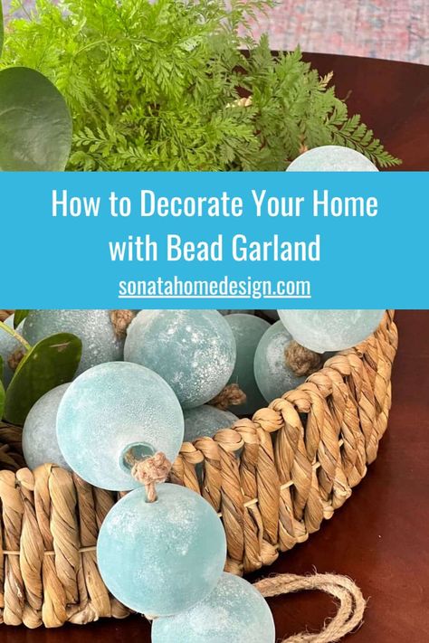 Looking to elevate your home decor and add a touch of elegance? Bead garland might just be the answer! With an array of colors, styles, and textures, there are many ways this charming home decor idea can instantly transform any space. From stylish home accents to creative decor tips, we have all the tips and ideas on how to decorate with budget friendly bead garlands Go to the Sonata Home Design blog for more details and inspiration! Home styling, unique decor ideas, kitchen decor, living room. Beach Bowl Decor, Beads In A Bowl Decor, Styling Beads Decor, Decorating With Bead Garland, Large Beads Decor, Decorating With Beads Garland, Coastal Tray Decor Ideas, Decorating With Beads, Large Bowl Decor Ideas