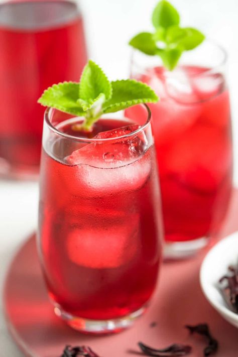 Hibiscus drink is an herbal beverage made from dried roselle flowers. It offers a beautiful crimson shade, comes with several health benefits, and is very easy to make. Refreshingly tart and sweet, this drink is great for summer, dinners, get-togethers, and parties. #hibiscustea #hibiscusdrink #rosellatea #roselladrink #roselleflowers #hibiscusflowers #thaidrink #thaifood #น้ำกระเจี๊ยบ Roselle Juice, Roselle Tea, Hibiscus Tea Benefits, Hibiscus Drink, Butterfly Pea Tea, Dried Hibiscus Flowers, Summer Drinks Alcohol, Asian Sauce, Herbal Drinks