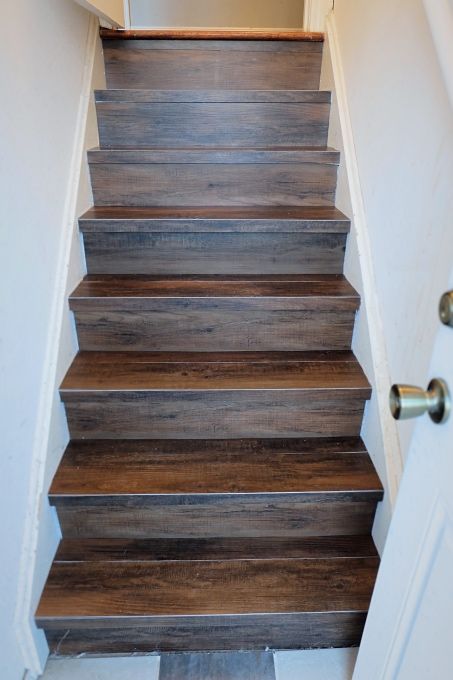 A DIY install of peel and stick wood-look vinyl flooring on our back stair. Faux Wood Tiles, Cellar Ideas, درج السلم, Stair Makeover, Peel And Stick Wood, Stairs Makeover, Tile Stairs, Staircase Makeover, Basement Stairs