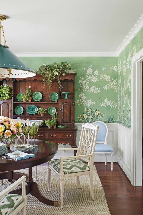 This lush hand-painted Gracie wallpaper brings the outside indoors in the dining room of this midcentury ranch home tucked among verdant rolling hills. The table is by Century, and the lighting is by Visual Comfort & Co. Gracie Wallpaper, Mark Sikes, Veranda Magazine, Green Dining Room, Mid Century Ranch, Traditional Dining, Green Walls, Chinoiserie Wallpaper, Brown Furniture